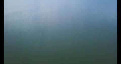 Calm lake with distant hilly landscape at daytime Stock Footage 314797724