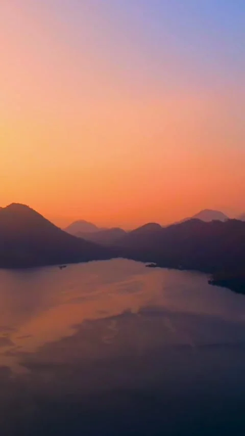 Calm lake during a vibrant sunset with a colorful sky Stock Footage 338046360