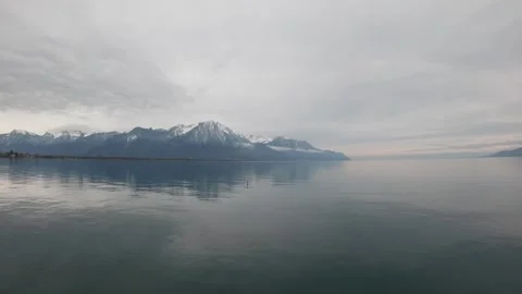 Calm Lake Geneva with Alpine reflections and cloudy sky Switzerland 動画素材 330951848
