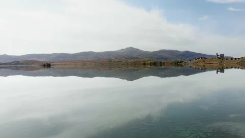 Calm lake in mountains under cloudy sky Stock Footage 153859841