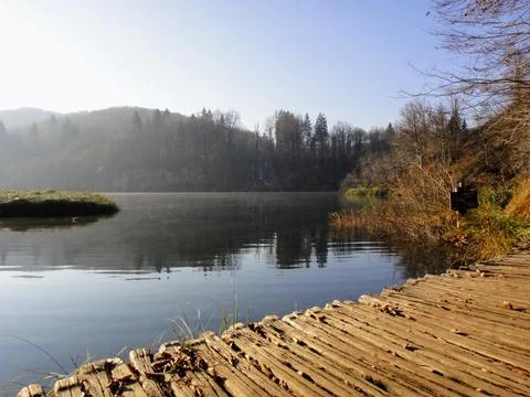 Calm   lake   by   rustic   boardwalk Stock Photos