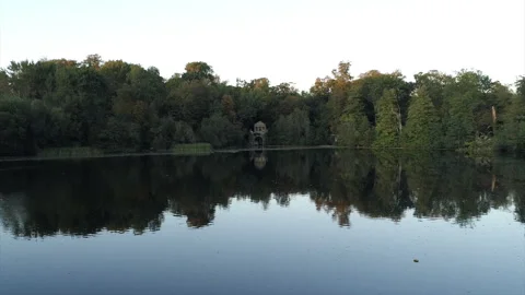 A calm lake with trees in the background Stock Footage 301627954