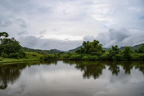 A calm lake with trees in the background Stock Photos