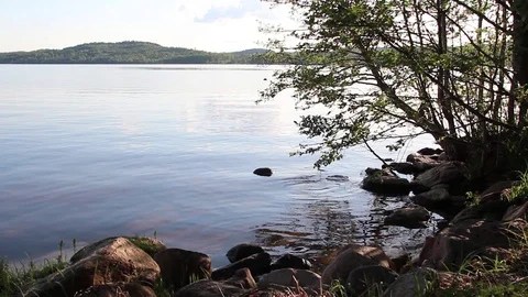 Calm Lake View with water lapping rocks 库存影片 89975760