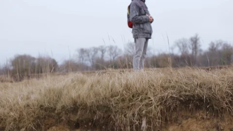 Calm man with backpack standing on grassy hill Stock Footage 128572823