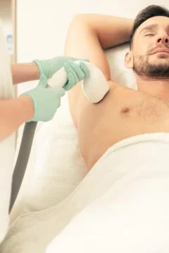Calm man having closed eyes during the laser hair removal procedure Foto stock