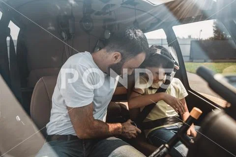 Calm man instructing satisfied boy in helicopter Stock Photos