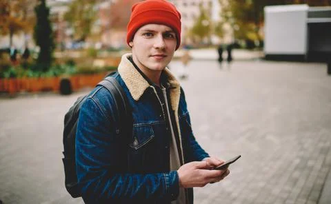 Calm man messaging on smartphone while walking Stock Photos