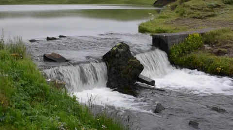 Calm mirror surface lake and a waterfall, Kirkjubæjarklaustur, South Iceland Stock Footage 40876472