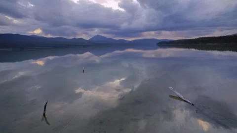 Calm mountain lake reflecting cloudy sky timelapse Stock Footage 345122438