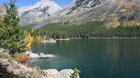 Calm mountain lake with small waves and surrounded by rocks and mountains  Stock Footage 219225108
