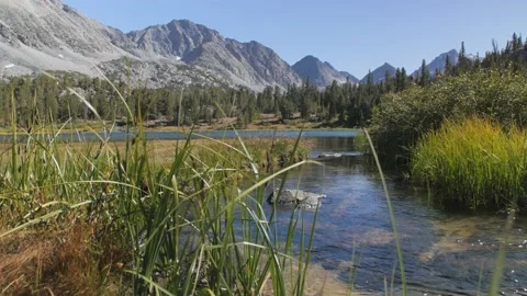 Calm mountain stream with mountains in background Stock Footage 146028235