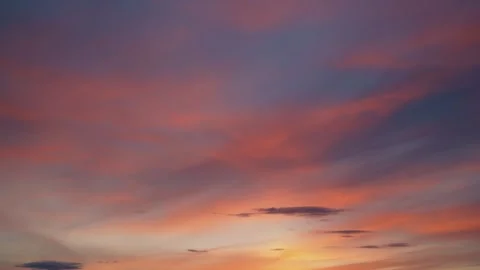The calm movement of fluffy colorful clouds across the blue sky at sunset. Stock Footage 333206301