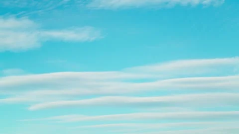 The calm movement of fluffy white clouds across the blue sky. 스톡 동영상 332476053