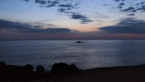 Calm ocean in the evening. Small rock. Sunset. Dark clouds. Ships on the hori Stock Footage 154830526