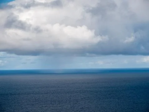 Calm ocean horizon under dramatic cloudy sky Stock Photos