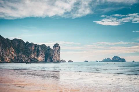 Calm ocean, limestone cliff, cloudy sky. Thailand. Stock-Fotos