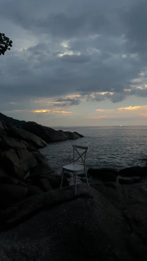 Calm ocean merging with a cloudy sky painted with the soft orange and grey hues Stock Footage 327638157