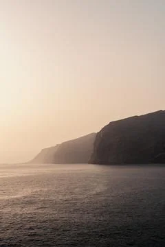 A calm ocean with a mountain in the background Stock Photos