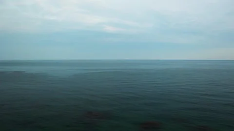 Calm ocean panorama with subtle waves under twilight sky. Serene seascape at Stock Footage 258814243