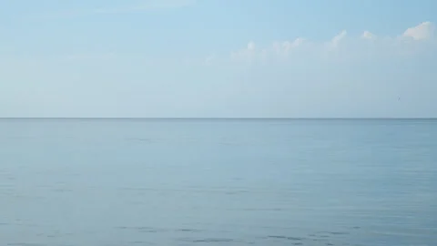 Calm ocean reflecting blue sky with few clouds in soft colors. Stock Footage 311470426