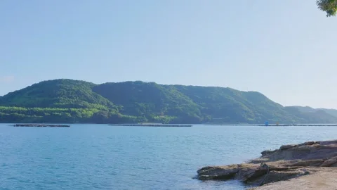 Calm ocean scenery with distant green mountains and calm water in Saga Japan Stock Footage 340749700