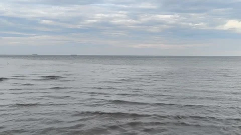 A calm ocean stretch under a cloudy sky Stock Footage 340130602