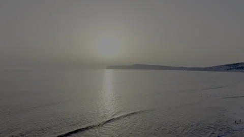 A calm ocean with a sun setting in the background Stock-Footage 298282857