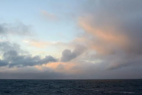 Calm Ocean at Sunset with Dramatic Clouds Stock Photos