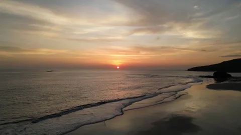 Calm Ocean Sunset Over Gentle Waves and Tropical Coastline Stock Footage 320604664