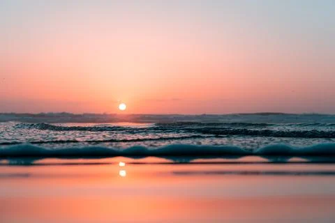 Calm Ocean Sunset with Soft Waves and Reflections Stock Photos