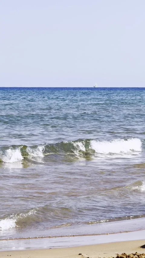 Calm ocean surf rolling onto sandy beach Video stock 343532563