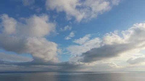 Calm ocean surface with dramatic clouds reflecting on peaceful water Stock Footage 327840194