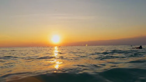 Calm Ocean Surface Glowing Under a Colorful Sunset Sky With Gentle Waves and Ref Stock Footage 337061047