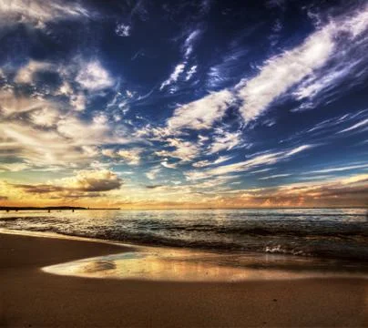 Calm ocean under dramatic sunset sky. amazing cloudscape Stock Photos