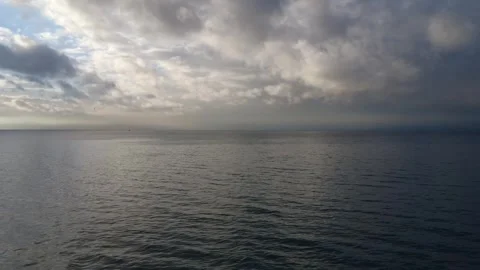 Calm Ocean Under Gray Cloudy Sky with Foggy Horizon Stock Footage 343993100