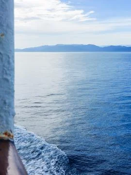 Calm Ocean View with Distant Mountains Captured from a Boat. Stock Photos