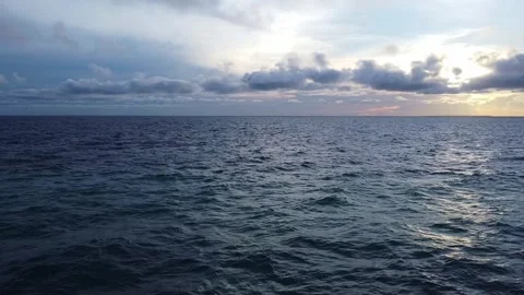 Calm ocean view under a cloudy sky at dusk, creating a serene and peaceful scene Stock Footage 318370667
