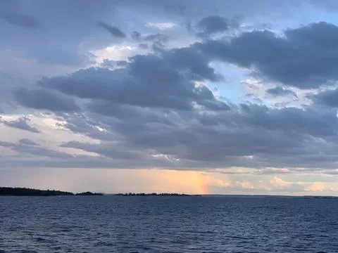 Calm ocean view under cloudy sky with sunset light Stock Photos
