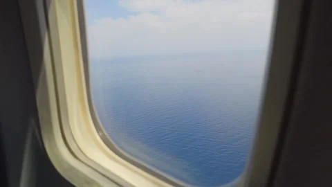 Calm ocean viewed from an airplane window, evoking peace and travel in 4k s.. Stock Footage 285122630