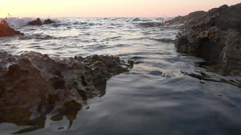 Calm ocean water flowing gently between rugged dark coastal rocks. Stock Footage 337406199