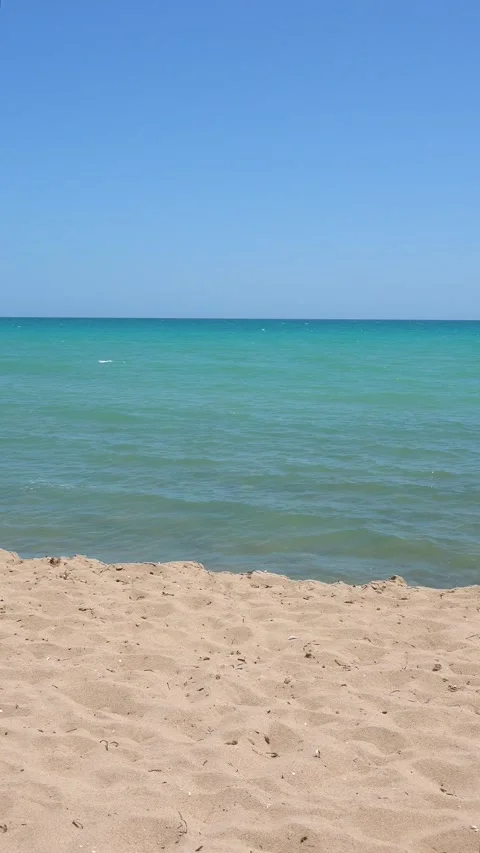 Calm ocean water lapping gently on a tropical beach on a sunny day Stock Footage 283535040