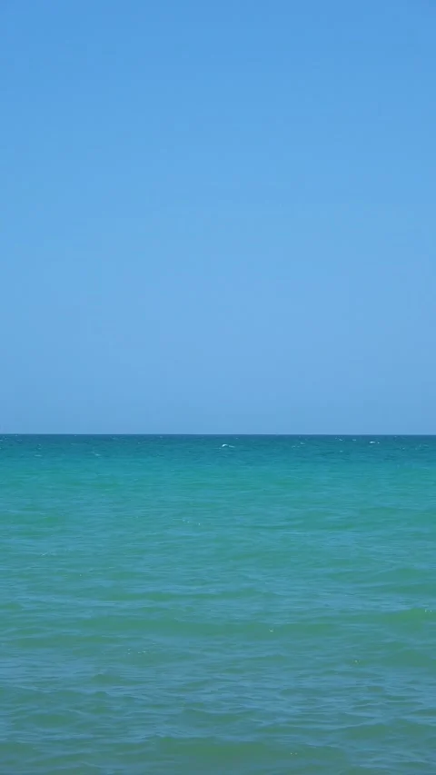 Calm ocean water lapping gently on a tropical beach on a sunny day Stock Footage 283536274