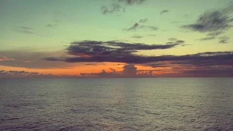 Calm ocean waters under a vibrant sunset sky with clouds casting shadows ac.. Stock Footage 338281710