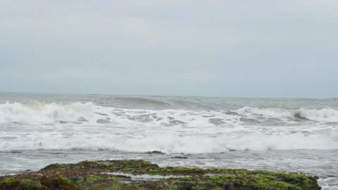 Calm ocean waves breaking on a sandy shore under a cloudy sky. Stock Footage 331087227