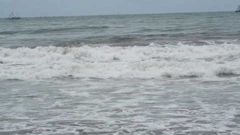 Calm ocean waves breaking on a sandy shore under a cloudy sky. Stock Footage 331128406