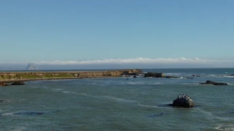 Calm ocean waves crash onto rocks on empty beach coast A Stock Footage 125341098