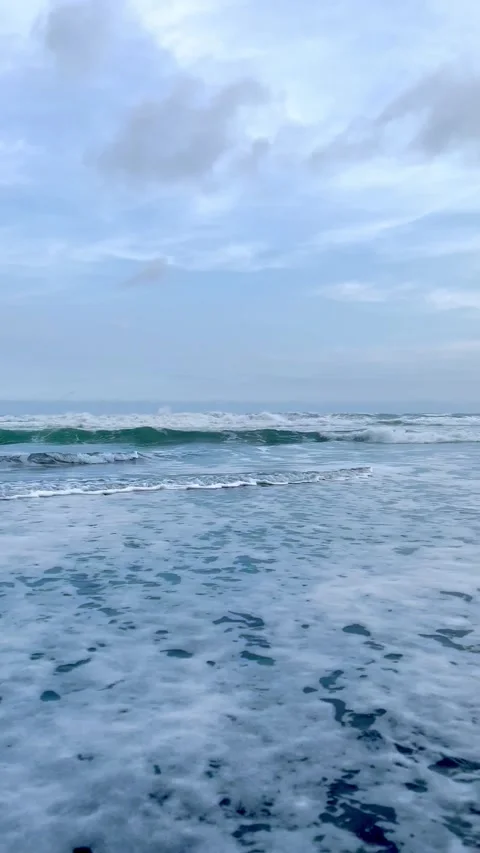 Calm Ocean Waves Crashing on Black Sand Beach under Cloudy Sky Stock Footage 340256958