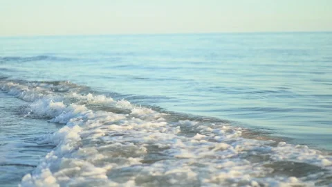 Calm ocean waves gently lap the shore at a serene beach during early morning Stock Footage 287786824