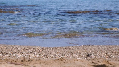 Calm ocean waves gently lapping at a pebbled shore Video stock 98183920
